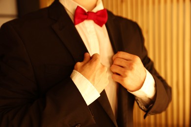 Photo of Man with bow tie getting ready indoors, closeup
