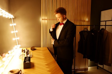 Photo of Handsome man getting ready near dressing table indoors