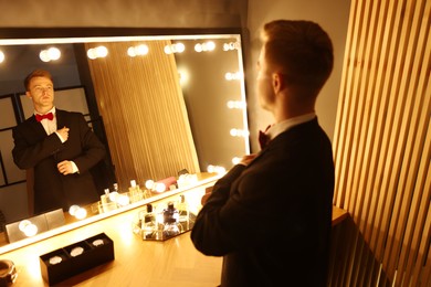 Photo of Handsome man getting ready near dressing table indoors