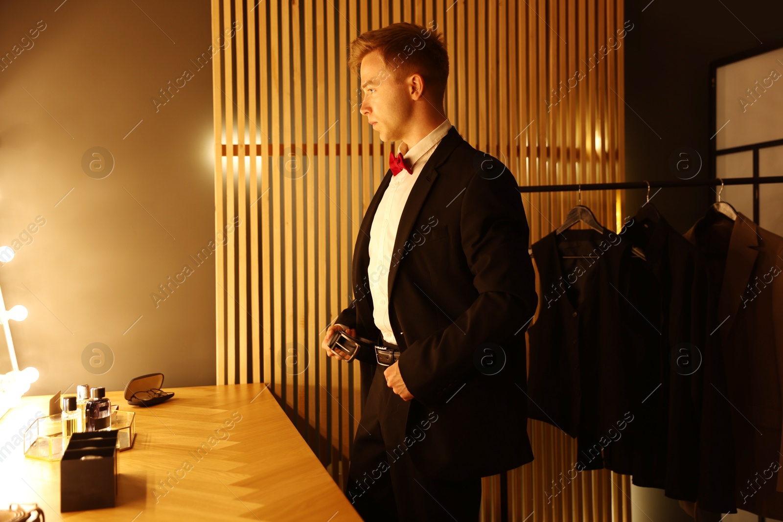 Handsome man getting ready near dressing table indoors Photo of Handsome man getting ready near dressing table indoors