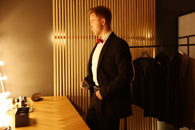 Photo of Handsome man getting ready near dressing table indoors