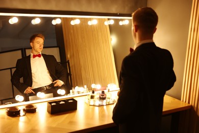 Photo of Handsome man getting ready near dressing table indoors