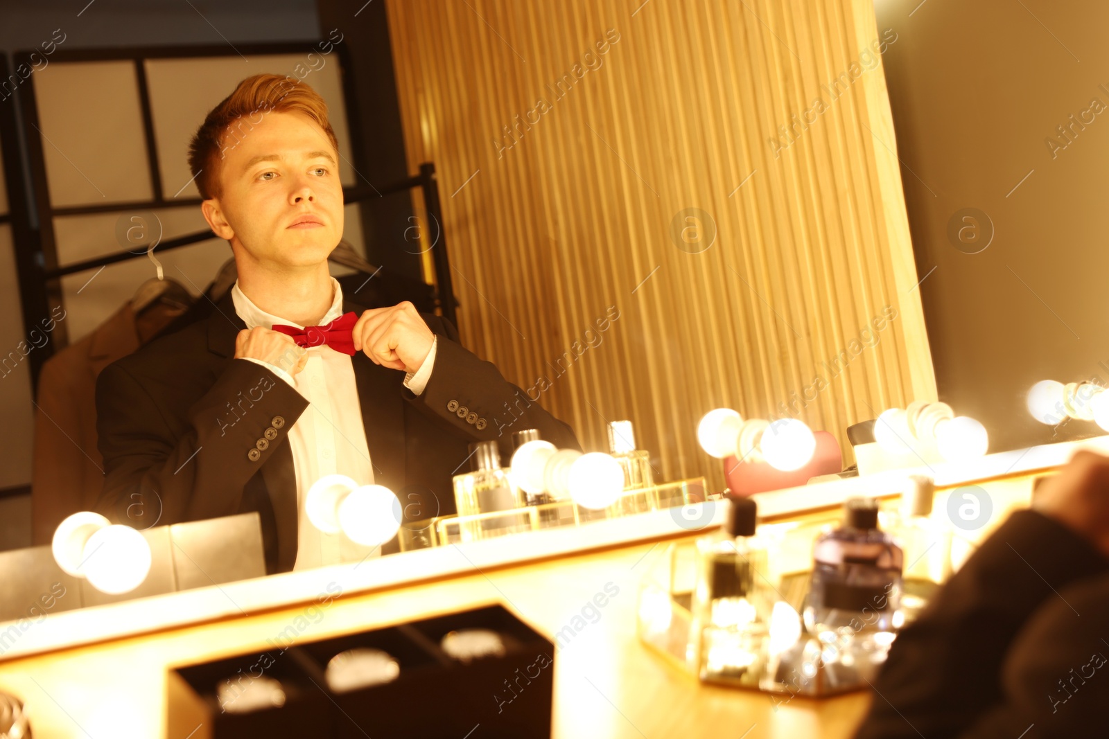 Handsome man getting ready near dressing table indoors Photo of Handsome man getting ready near dressing table indoors