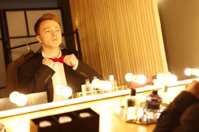 Photo of Handsome man getting ready near dressing table indoors