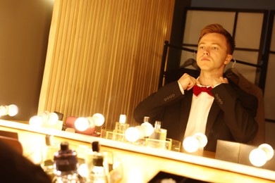 Photo of Handsome man getting ready near dressing table indoors