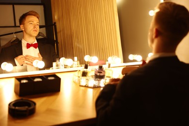 Photo of Man getting ready at dressing table indoors