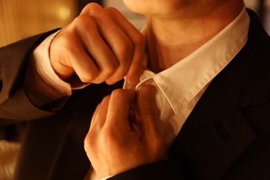 Photo of Man in stylish outfit getting ready indoors, closeup