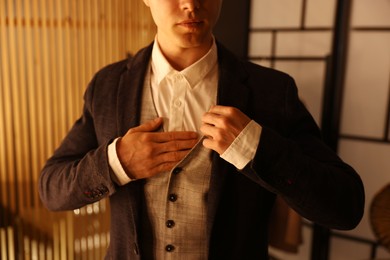 Photo of Man in stylish outfit getting ready indoors, closeup