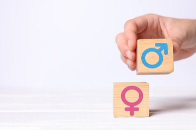 Image of Sex education. Woman putting cube with male gender symbol next to another one with female on white background, closeup