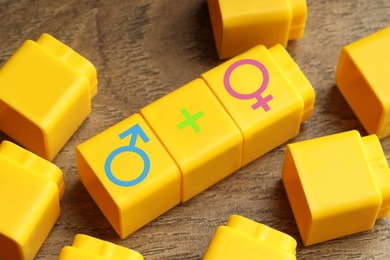 Image of Sex education. Yellow cubes with female and male gender symbols and plus sign on wooden background