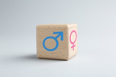 Image of Sex education. Wooden cube with female and male gender symbols on grey background