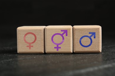 Image of Sex education. Wooden cubes with female and male gender symbols on table