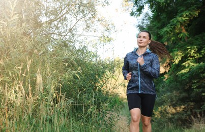 Photo of Beautiful woman in sportswear running in forest