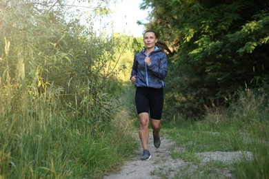 Photo of Beautiful woman in sportswear running in forest