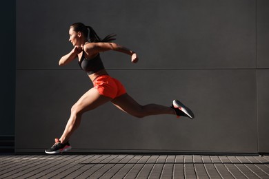 Photo of Woman in sportswear running near building outdoors