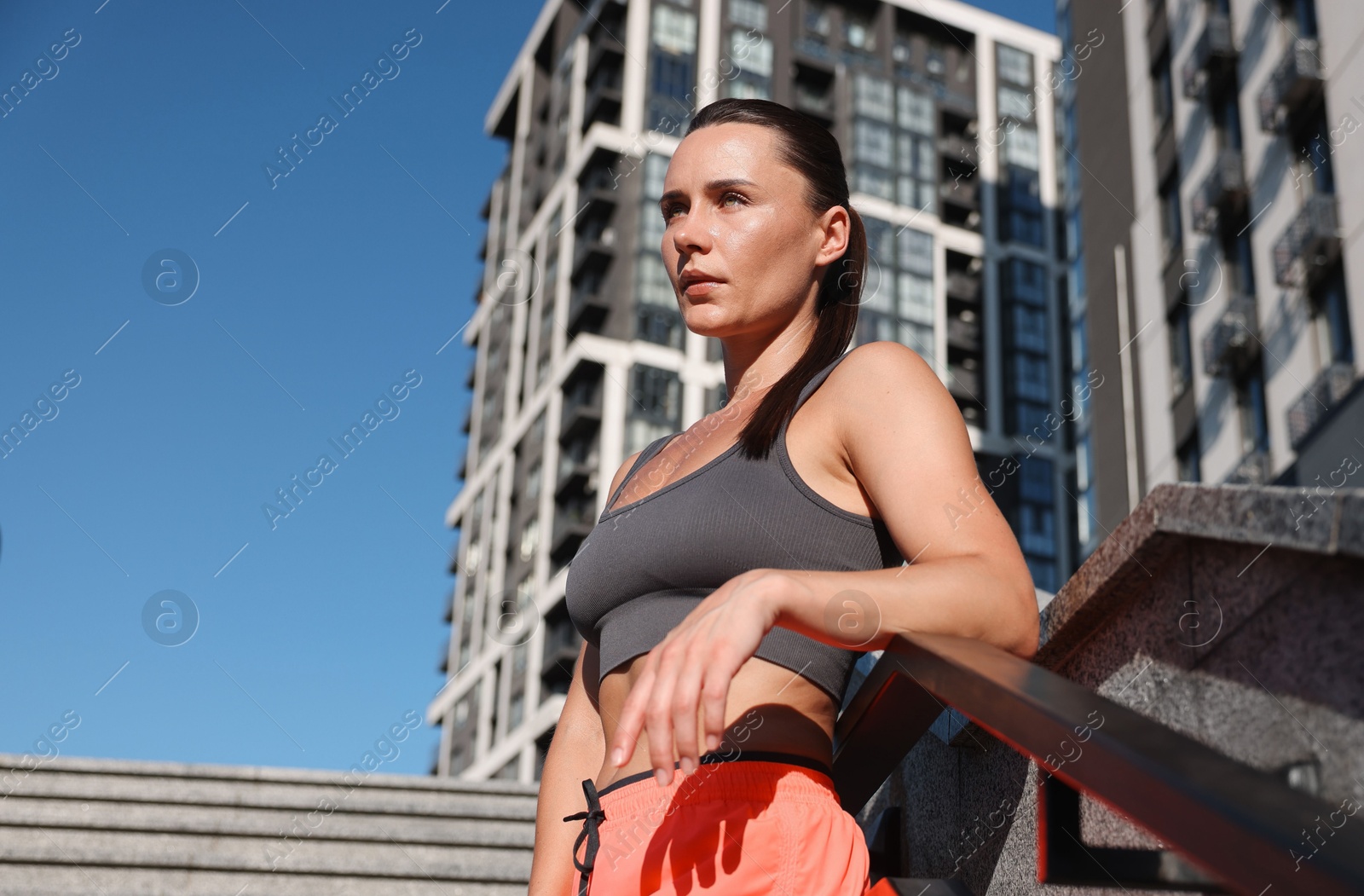Beautiful woman in sportswear before running on stairs outdoors, low angle view Photo of Beautiful woman in sportswear before running on stairs outdoors, low angle view