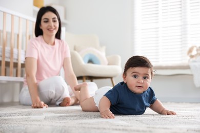 Photo of Happy mother with her cute little baby at home, selective focus