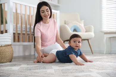 Photo of Happy mother with her cute little baby at home, selective focus
