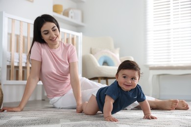 Photo of Happy mother with her cute little baby at home, selective focus