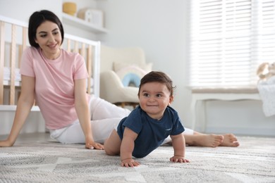Photo of Happy mother with her cute little baby at home, selective focus