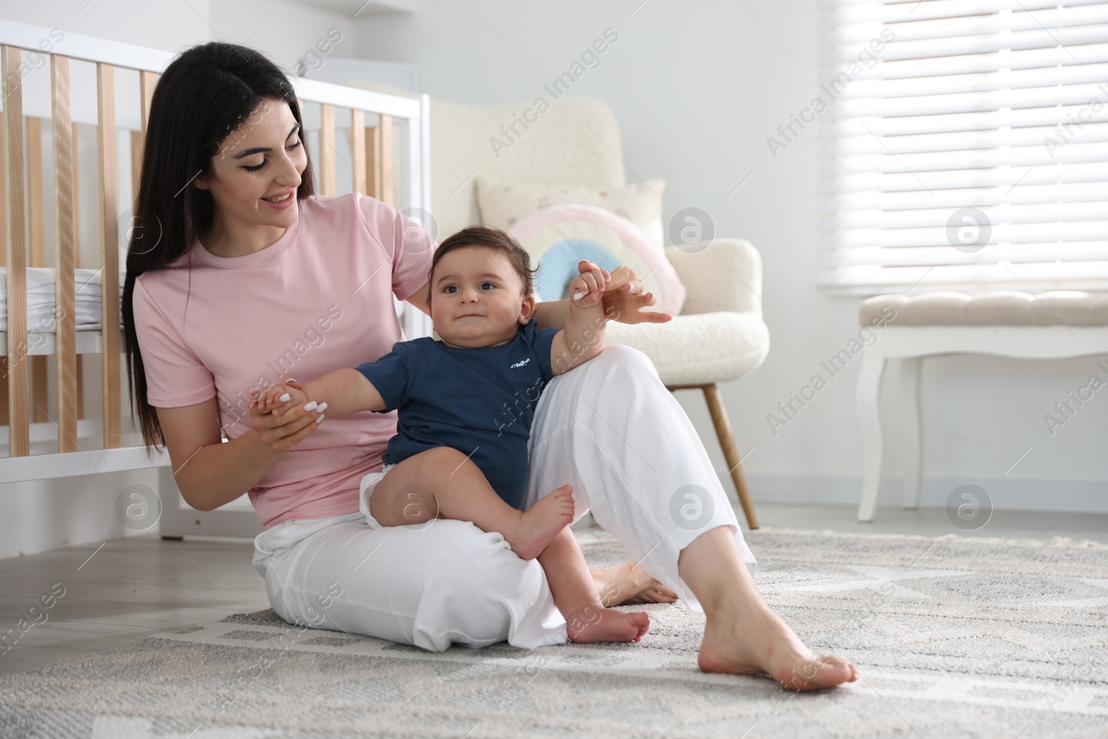 Photo of Happy mother with her cute little baby at home, space for text