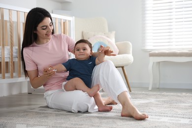 Photo of Happy mother with her cute little baby at home, space for text