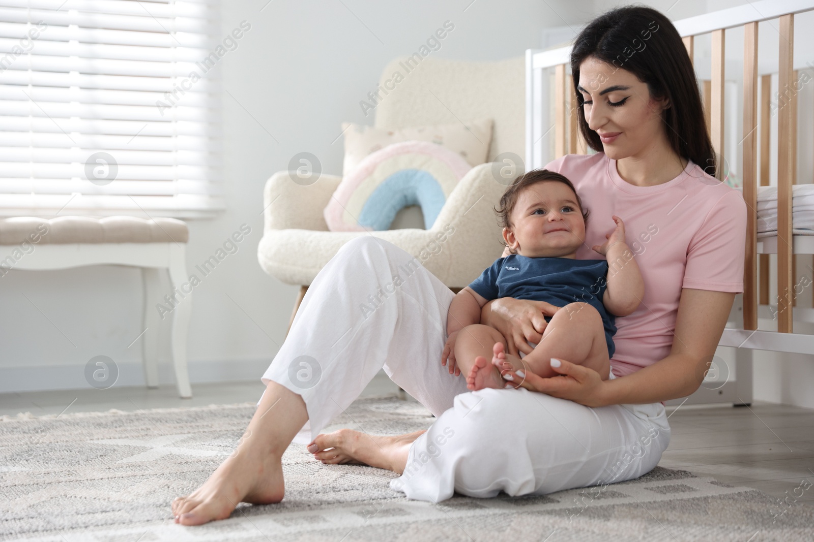 Happy mother with her cute little baby at home, space for text Photo of Happy mother with her cute little baby at home, space for text