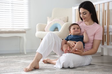 Photo of Happy mother with her cute little baby at home, space for text