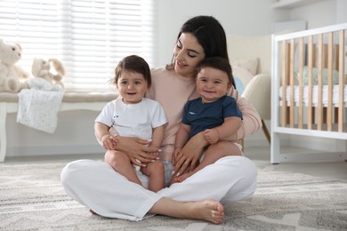 Photo of Happy mother with her cute little twin babies at home