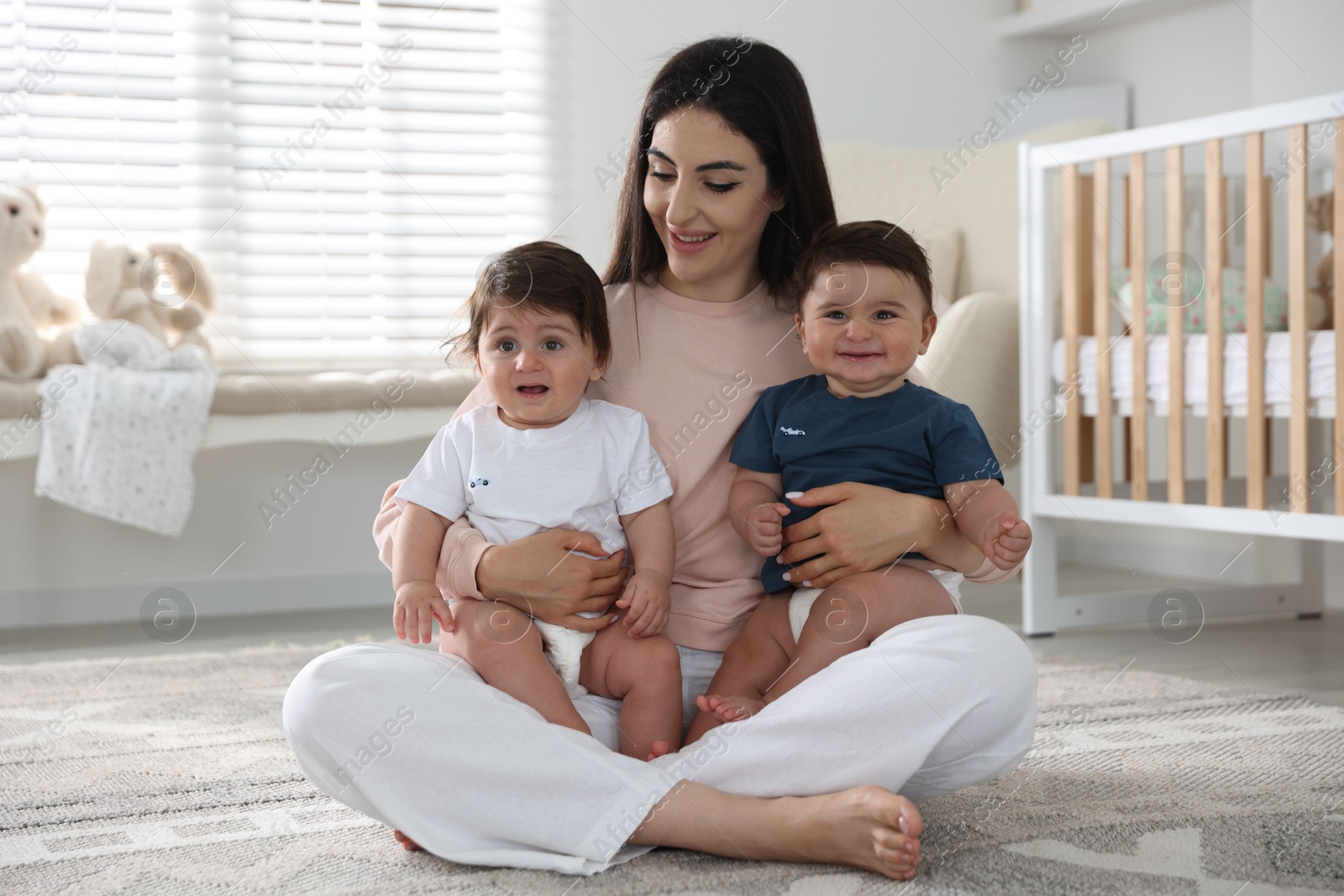 Happy mother with her cute little twin babies at home Photo of Happy mother with her cute little twin babies at home