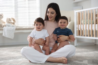 Photo of Happy mother with her cute little twin babies at home