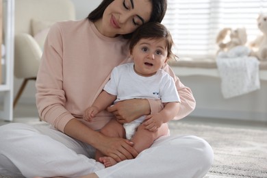 Photo of Happy mother with her cute little baby at home