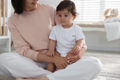 Photo of Happy mother with her cute little baby at home, closeup