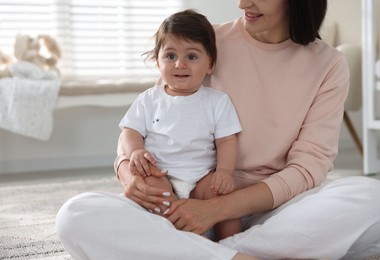 Photo of Happy mother with her cute little baby at home, closeup