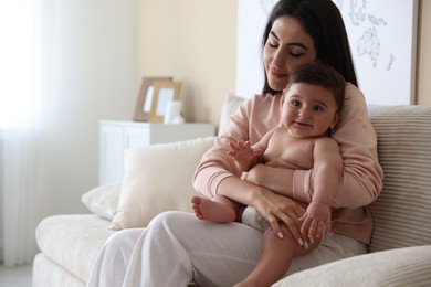 Photo of Happy mother with her cute little baby at home, space for text