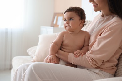 Photo of Happy mother with her cute little baby at home, closeup. Space for text