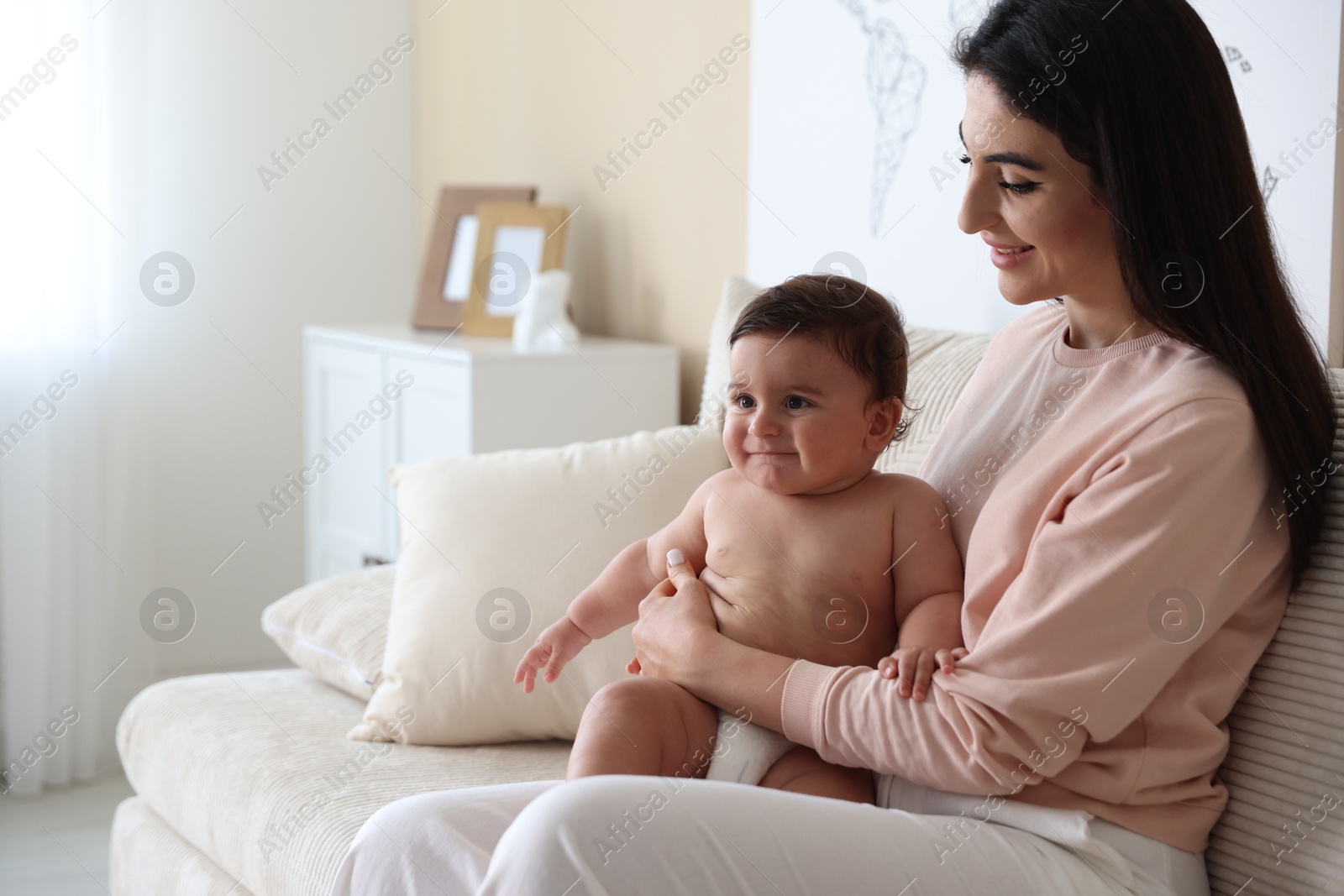 Happy mother with her cute little baby at home, space for text Photo of Happy mother with her cute little baby at home, space for text
