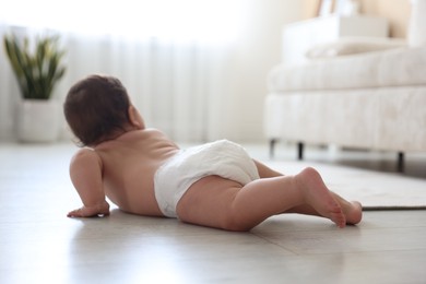 Photo of Cute little baby crawling on floor at home, selective focus