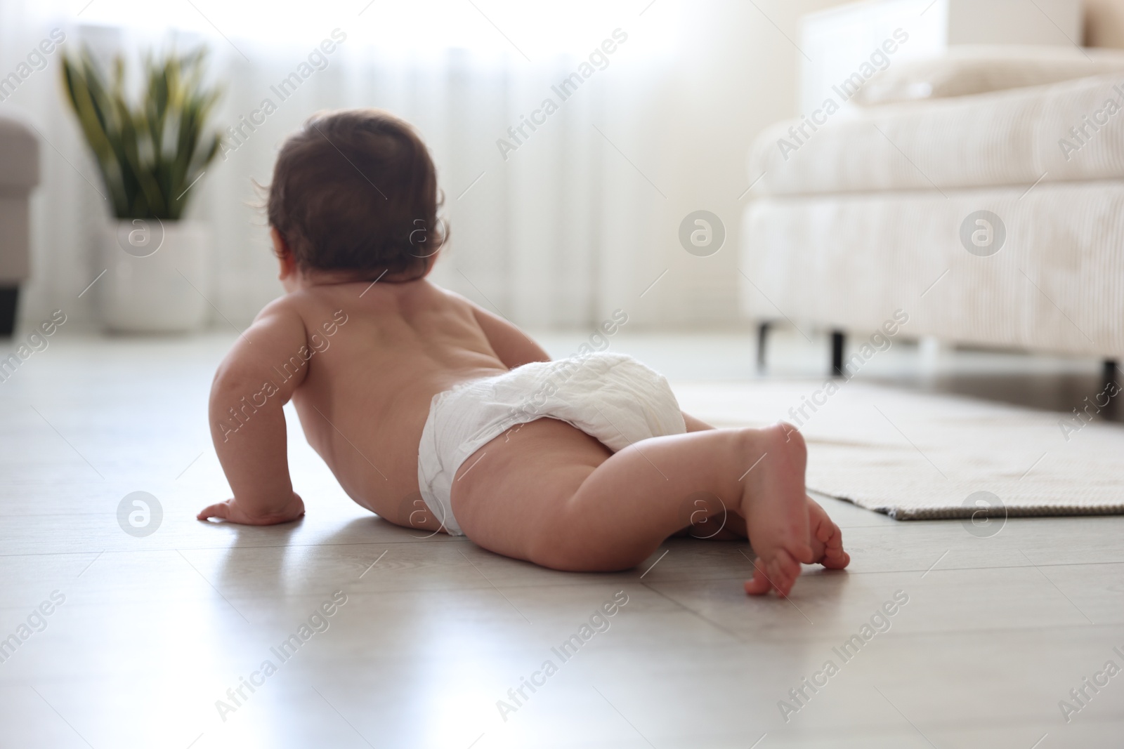 Cute little baby crawling on floor at home, selective focus Photo of Cute little baby crawling on floor at home, selective focus