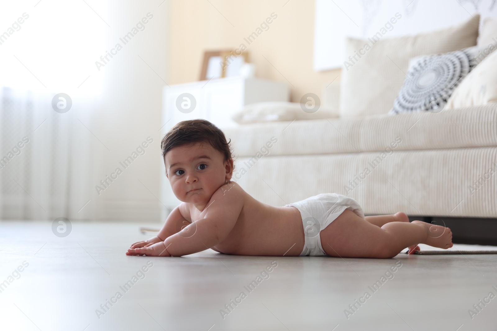 Cute little baby crawling on floor at home Photo of Cute little baby crawling on floor at home