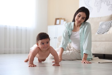 Photo of Happy mother with her cute little baby at home, selective focus