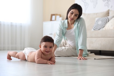 Photo of Happy mother with her cute little baby at home, selective focus