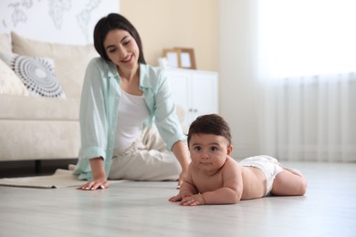 Photo of Happy mother with her cute little baby at home, selective focus
