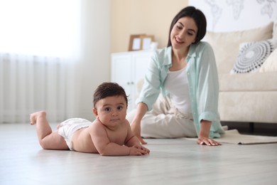 Photo of Happy mother with her cute little baby at home, selective focus