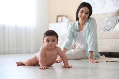 Photo of Happy mother with her cute little baby at home, selective focus