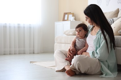 Photo of Happy mother with her cute little baby at home, space for text