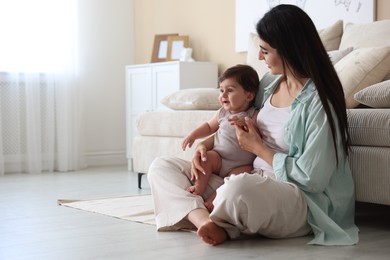 Photo of Happy mother with her cute little baby at home, space for text
