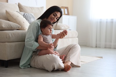 Photo of Happy mother with her cute little baby at home, space for text