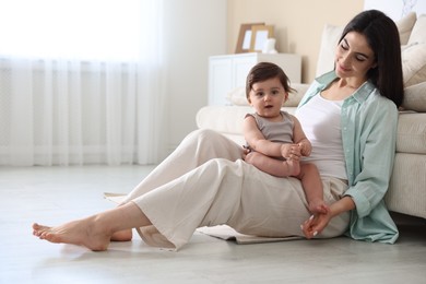 Photo of Happy mother with her cute little baby at home