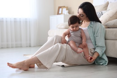 Photo of Happy mother with her cute little baby at home